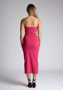 Back image of a model wearing a magenta midaxi dress with a graceful scoop neckline, slender straps, subtle side cut-out and it offers both mobility and modern flair with a front skirt split. The design featured is the Vesper Marilynn Magenta Midaxi Dress